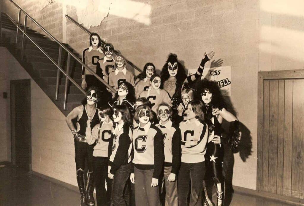 Inside Cadillac High School, KISS poses with the varsity cheerleading team.  Photo Courtesy of Cadillac Area Visitors Bureau